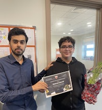 two men standing next to each other holding a certificate